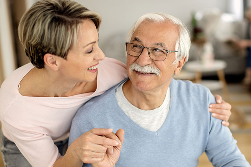 happy-caregiver-helping-man-with-parkinsons